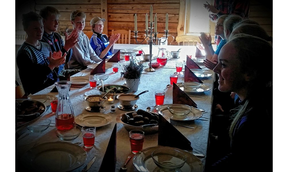 Trivsel ved langbordet. Maten smaker ekstra godt når man har høstet og skutt råvarene selv. Foto: May Britt Knudsen.