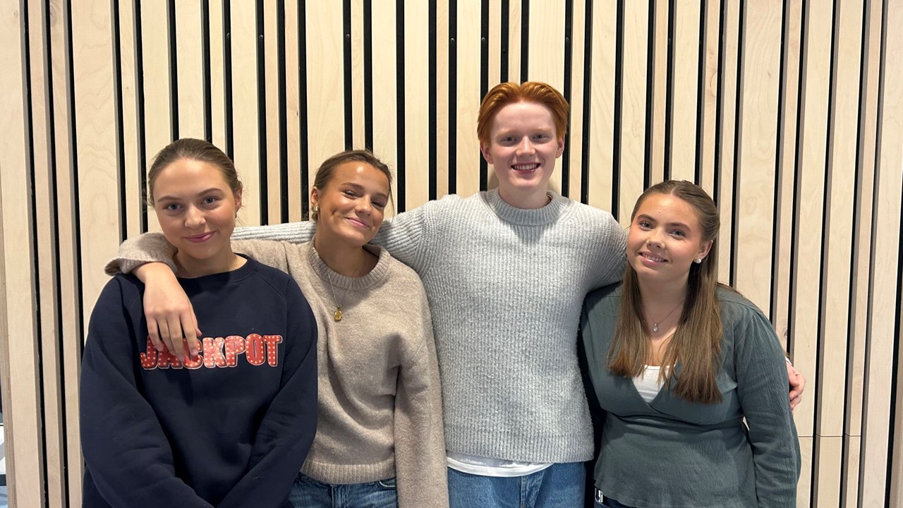 Fire elever ved Heimdal vgs som står ved en vegg med armene om hverandre