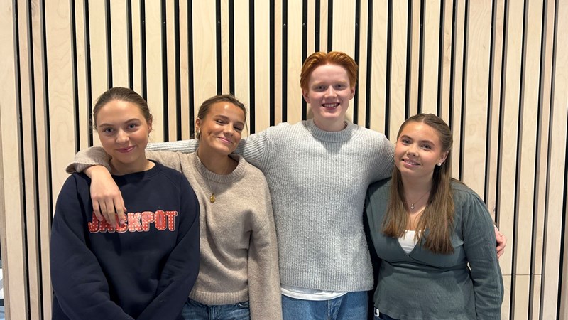 Fire elever ved Heimdal vgs som står ved en vegg med armene om hverandre