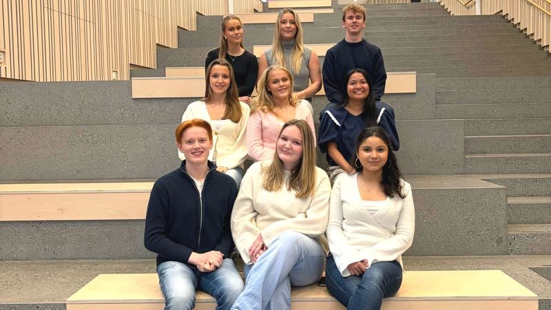 Elevrådsmedlemmene ved Heimdal vgs for skoleåret 2025-26 sittende i den store trappeoppgangen ved Hovedinngang Øst opp mot kantina.