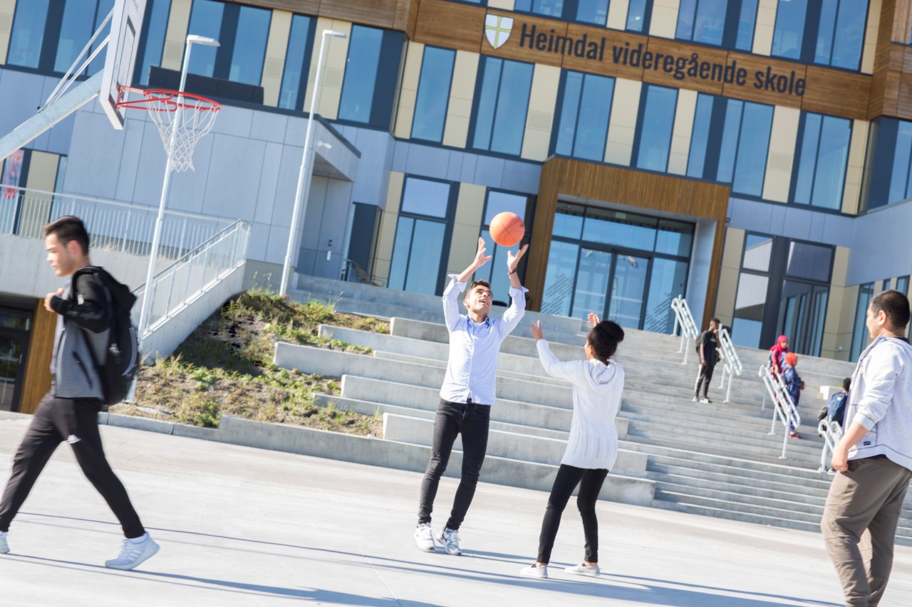 Elever som spille basketball på plassen foran Heimdal vgs-bygget