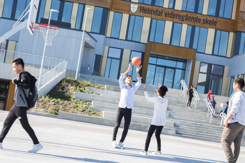 Elever som spille basketball på plassen foran Heimdal vgs-bygget