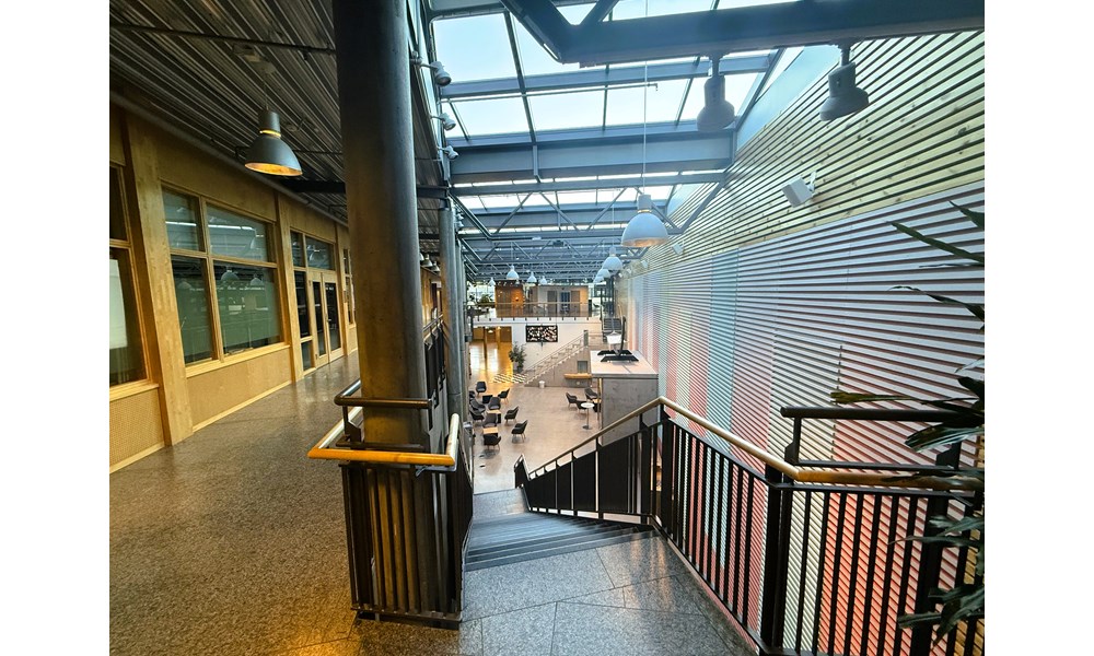 Dette bildet viser et stort, åpent atrium eller fellesområde i en moderne bygning